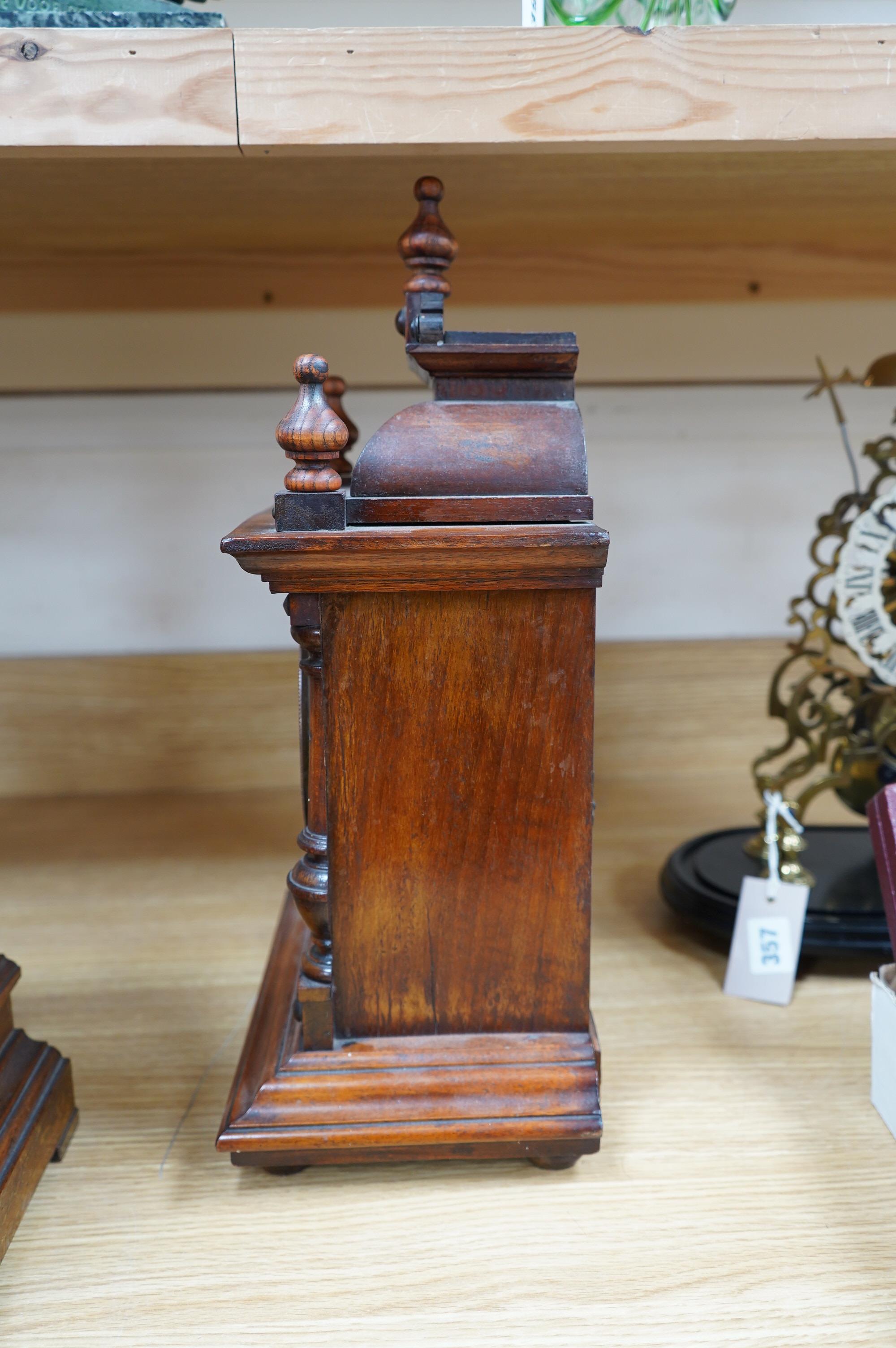 A late 19th century Black Forest walnut mantel clock with key and pendulum, 41cm. Condition - fair to good, not tested